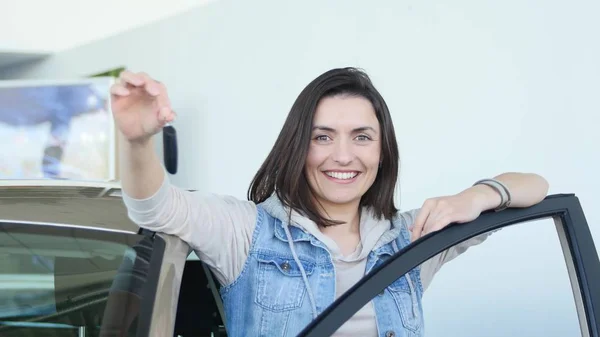 Mulher feliz motorista mostrando chaves do carro e inclinando-se na porta do carro — Fotografia de Stock