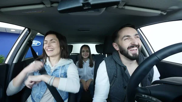 Feliz familia sonriente bailando en un coche familiar — Foto de Stock