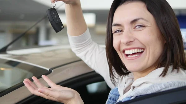 Szczęśliwa kobieta pokazując klucz jego nowy samochód. Auto, biznes, sprzedaż samochodów, technologia i ludzie koncepcja - zadowolony mężczyzna z dealerem samochodów w Pokaż auto lub salon — Zdjęcie stockowe