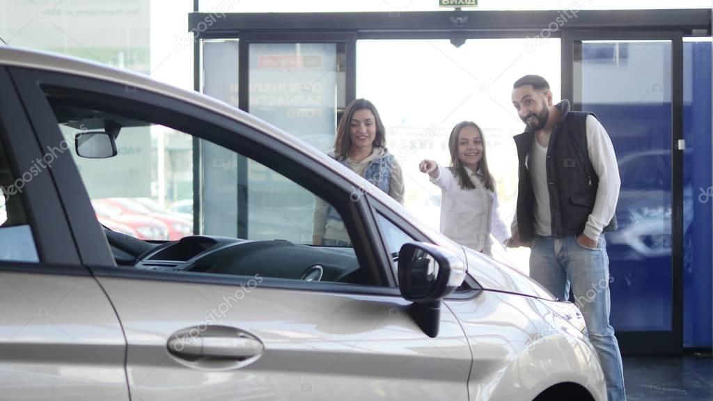 young family comes into Car dealership to choose the car to buy it