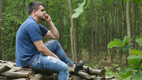 Joven hablando por teléfono en el bosque — Vídeo de stock