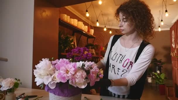 Blumenladen, Blumengeschäft, das moderne Bouquet arrangiert, junge hübsche Floristen arbeiten im Blumengeschäft, das Bouquet herstellt — Stockvideo