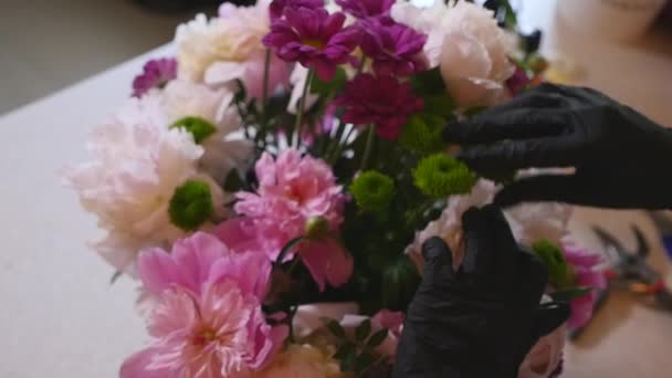 Florist hand göra buketter blommor i grå kruka — Stockvideo