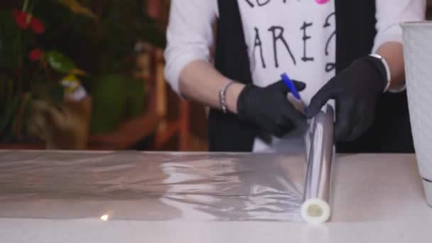 Florista mujer preparando papel para envolver un hermoso ramo de flores — Vídeos de Stock