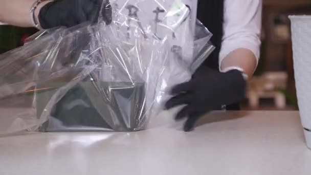Florista em própria loja de flor, preparando um pote para um buquê. de perto — Vídeo de Stock