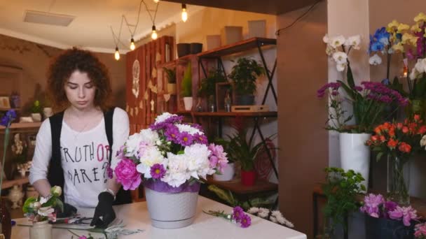 Çiçek Dükkanı, çiçekçi Modern buket düzenlenmesi, genç yakışıklı çiçekçi buket yapma çiçek dükkanında çalışmak — Stok video