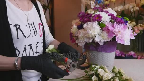Κοντινό πλάνο ανθοκόμος κάνει μια ανθοδέσμη των λουλουδιών. Peone και τριαντάφυλλα — Αρχείο Βίντεο
