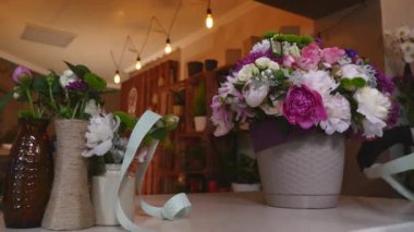 Çiçek Dükkanı, çiçekçi düzenlenmesi Modern buket, kurdele bağlama bir yay yapmak için genç yakışıklı çiçekçi buket yapma çiçek dükkanında çalışmak