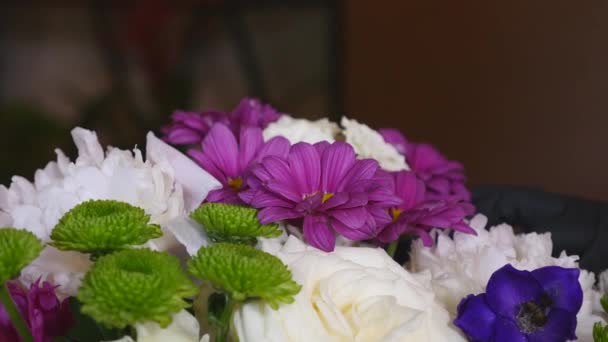 Флорист делает огромный красивый разноцветный букет, состоящий из разных цветов — стоковое видео