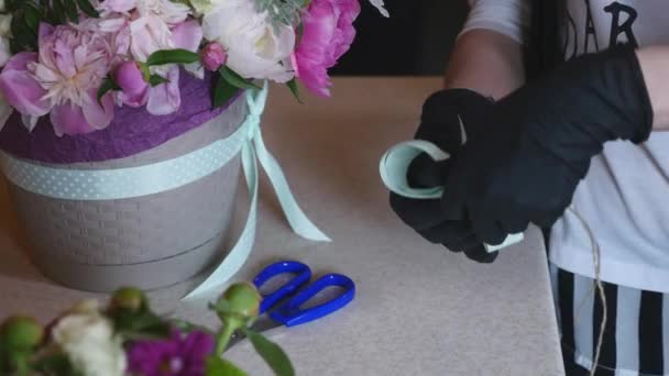 Top view of florist hands making flower bouquet with decorative ribbon — Stock Video