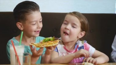 Çocuklar eğleniyor pizza bir kafede yemek