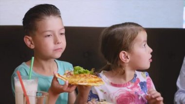 Çocuklar eğleniyor pizza bir kafede yemek