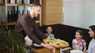 Garson hazır lezzetli pizza masanın üzerine koyar. yakın çekim