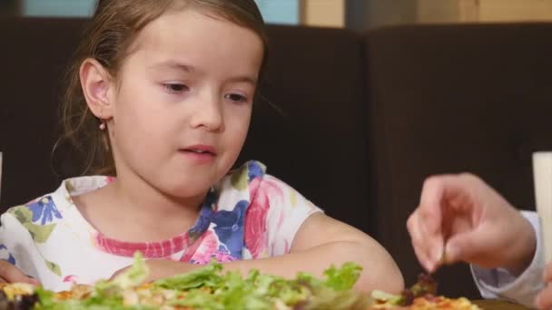 Madre y su hija comiendo pizza en la cafetería — Vídeo de stock