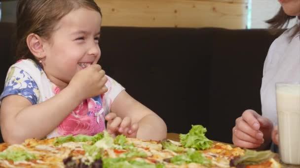 Madre y su hija comiendo pizza en la cafetería — Vídeo de stock