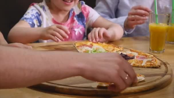 Barnen har roligt äter pizza på ett café — Stockvideo