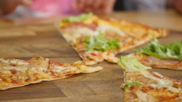 Handen nemen pizza bezuinigingen van plaat op tafel — Stockvideo