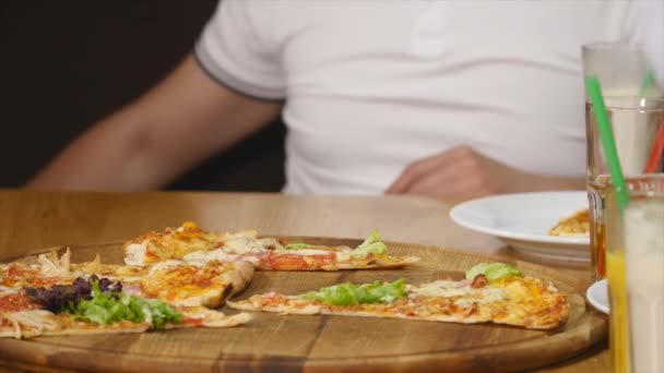 L'homme déchire la pizza. Gros plan — Video