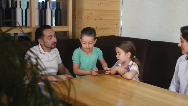 Familia sentada mesa juntos en un café — Vídeo de stock