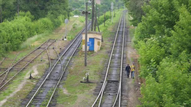 Zwei junge Leute gehen auf Bahngleise — Stockvideo