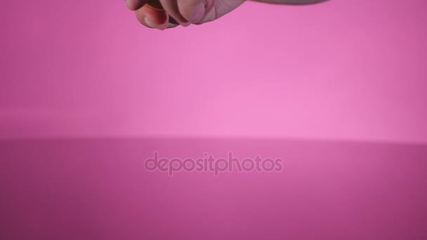 En trasiga ägg faller på bordet på den rosa bakgrunden — Stockvideo