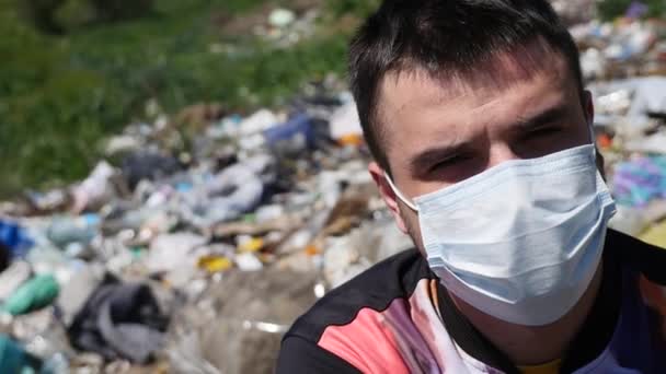 De man in het masker zit op de vuilnis — Stockvideo