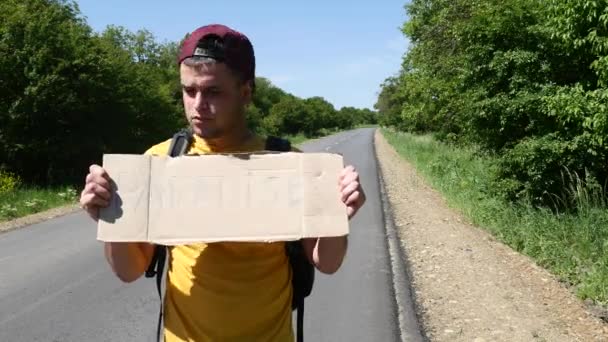 Turista en una camiseta amarilla muestra un signo — Vídeos de Stock