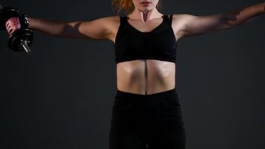 Spor kız siyah bir arka plan üzerinde egzersiz