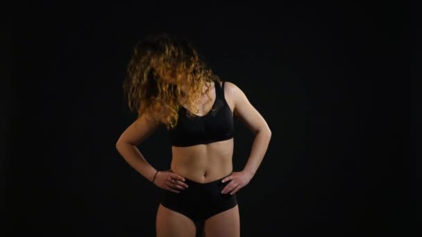 Esportes menina faz exercício em um fundo preto — Vídeo de Stock