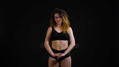 Genç güzel kadın egzersiz eğitim siyah arka plan üzerine