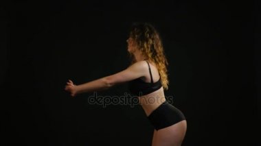 Genç güzel kadın egzersiz eğitim siyah arka plan üzerine