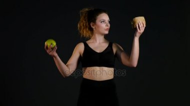 Hamburger ya da bir siyah arka plan üzerine izole elma arasında seçme şişman mutlu bir kadın portresi