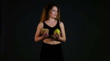 Hamburger ya da bir siyah arka plan üzerine izole elma arasında seçme şişman mutlu bir kadın portresi