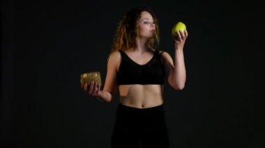 Hamburger ya da bir siyah arka plan üzerine izole elma arasında seçme şişman mutlu bir kadın portresi