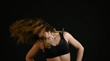 Spor kız siyah bir arka plan üzerinde egzersiz