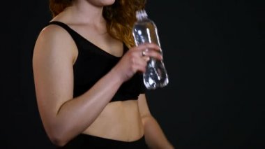 Kadın içme suyu şişe siyah arka plan üzerine uygun