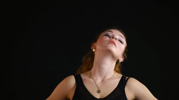 Girl doing exercises for the neck on a black background — Stock Video