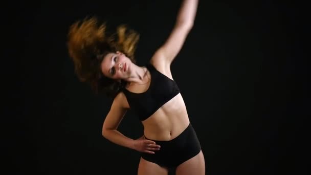 体育的女孩在一个黑色的背景上运动 — 图库视频影像