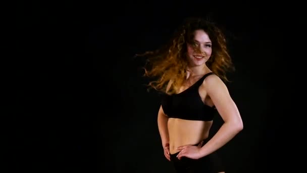 Una chica muy hermosa agitando su cabello sobre fondo negro — Vídeos de Stock