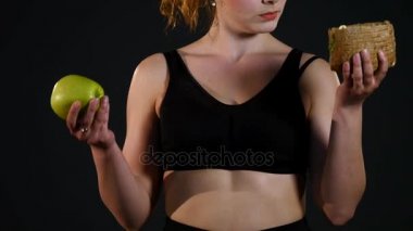 Hamburger ya da bir siyah arka plan üzerine izole elma arasında seçme şişman mutlu bir kadın portresi