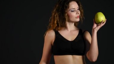 Hamburger ya da bir siyah arka plan üzerine izole elma arasında seçme şişman mutlu bir kadın portresi