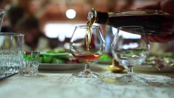 Versare il whisky nei bicchieri. Versato da una bottiglia di whisky nei bicchieri — Video Stock