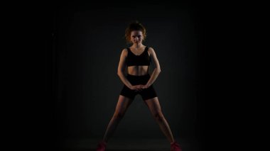 Lunges siyah arka plan üzerine yapıyor kız