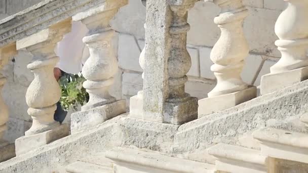 幸福的新郎爬上楼梯，和举行婚礼花束 — 图库视频影像