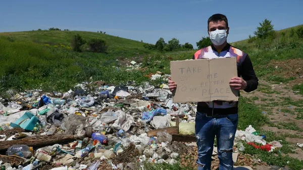 A pessoa na máscara no lixo segura um sinal com o texto — Fotografia de Stock