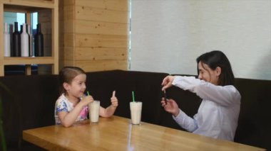 Çocuk anne ne zaman üstünde hareket eden telefon fotoğraf çekme restoranda kokteyl içme