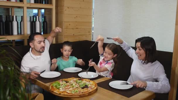 Familj på fyra njuter sin pizza lunch på ett café — Stockvideo