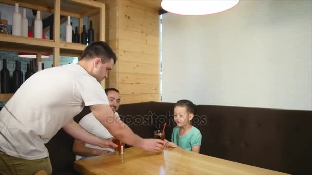 Padre e hijo pequeño sentados en la cafetería con jugo y bebida — Vídeos de Stock