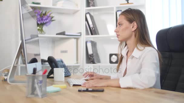 Beautiful young woman working in office and drink coffee — Stock Video