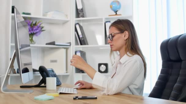 Красива молода жінка працює в офісі — стокове відео